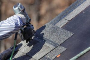 Roof shingles, flashing, and a ceiling water stain showing common signs of a roof leak.